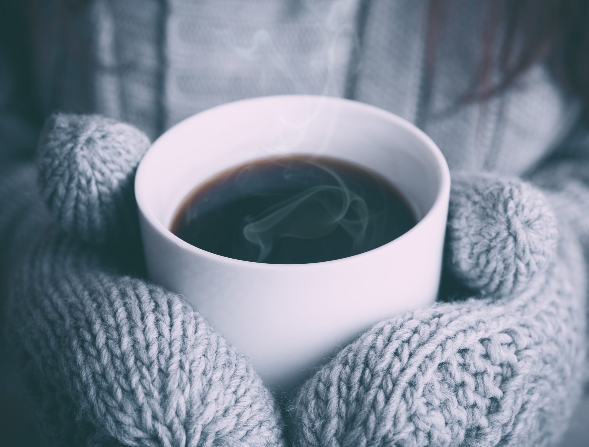 mains tenant une tasse de café